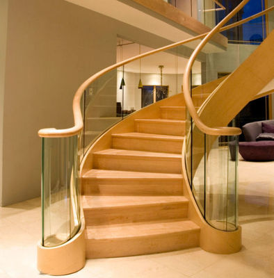 Деревянным лестница покрытая зерном современная изогнутая легкая устанавливает с стеклянными перилами